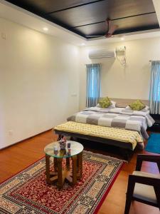a room with two beds and a table in it at Castle Villa in Ernakulam