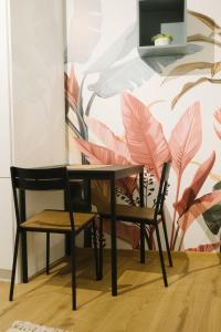 uma mesa e duas cadeiras em frente a uma parede em meebo apartments em Novi Sad