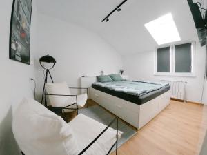 a bedroom with a bed and a chair in it at meebo apartments in Novi Sad