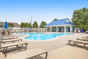 a swimming pool with chairs and a building at Millville by the Sea --- 23772 Pembroke Lane in Millville