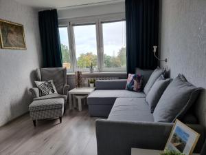 sala de estar con sofá azul y sillas en Skwer Kościuszki Gdynia en Gdynia
