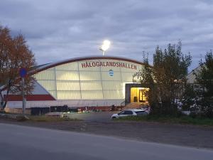 a large building with a car parked in front of it at Åsveien Apartments. in Harstad