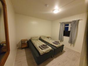 a small bedroom with a bed and a window at Åsveien Apartments. in Harstad