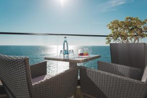 uma mesa e cadeiras numa varanda com o oceano em Kalamper Hotel & Spa em Dobra Voda