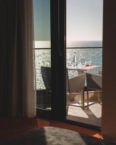 um quarto com vista para o oceano através de uma porta em Kalamper Hotel & Spa em Dobra Voda