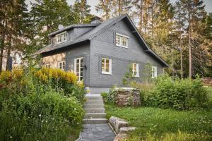 una casa gris con techo de gambrel en Ferienhaus Asten-Lodge en Winterberg