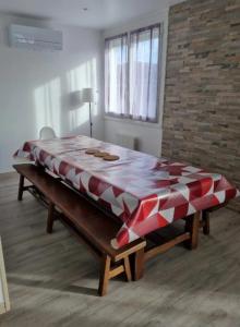Ce lit se trouve dans un dortoir doté d'une couverture rouge et blanche. dans l'établissement Maison de Nicolas et Sonia, à Bort-les-Orgues