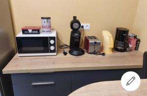 un comptoir avec un four micro-ondes et une radio. dans l'établissement Maison de Nicolas et Sonia, à Bort-les-Orgues
