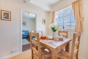 ein Esszimmer mit einem Holztisch mit Obst darauf in der Unterkunft Cottage 9 Old Farmhouse Braithwaite in Keswick + 1 Foto