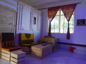 una stanza con due sedie e un tavolo e finestre di L&J Modern Backpackers Kigamboni Beach House a Dar es Salaam