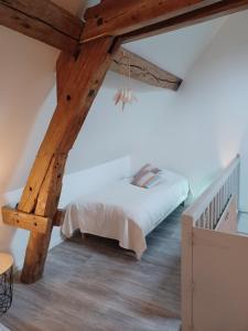 - une chambre avec un lit et un plafond en bois dans l'établissement l'Eden caché, à Beaune-la-Rolande