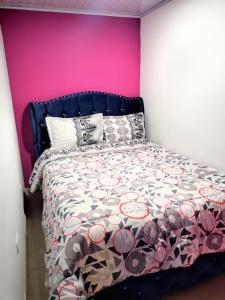 a bedroom with a bed with a pink wall at The Mural Hostel Bogotá in Bogotá