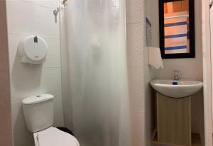 een badkamer met een toilet en een wastafel bij The Mural Hostel Bogotá in Bogota