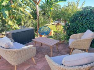 a patio with wicker chairs and a table and a grill at Ca Emma in Mahuella