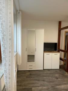 um quarto com uma cozinha com armários brancos e um micro-ondas em Diyo Apart Festspiel Bayreuth em Bayreuth