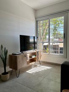 un soggiorno con TV e ampia finestra di Hermoso Departamento Zona Residencial Mendoza a Mendoza