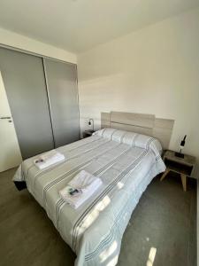 een slaapkamer met een groot bed en 2 handdoeken bij Hermoso Departamento Zona Residencial Mendoza in Mendoza