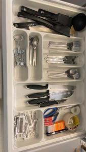 a drawer full of kitchen utensils in a refrigerator at Absolute Center Helsinki Compact Apartment in Helsinki