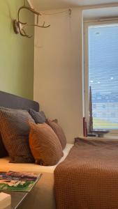 uma cama com almofadas e uma janela num quarto em Absolute Center Helsinki Compact Apartment em Helsinque