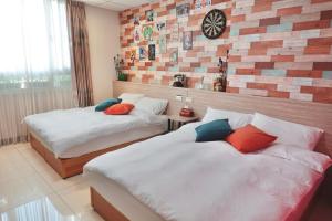 a bedroom with two beds and a clock on the wall at 斑比Bambi in Tainan