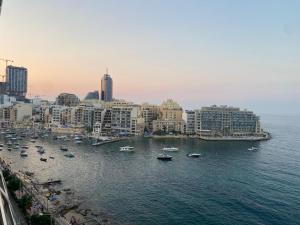 a view of a city with boats in the water at F2 2 Lovely room, living and bathroom shared , St Julians in St. Julianʼs