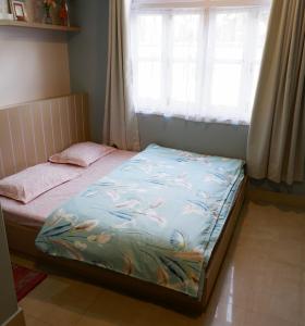 een klein bed in een kamer met een raam bij Tag Along Backpackers in Gangtok