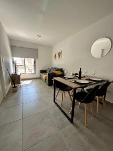een woonkamer met een tafel en stoelen en een bank bij Hermoso Departamento Zona Residencial Mendoza in Mendoza