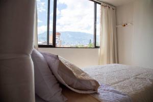 a bedroom with a bed and a large window at Estadías Marisol in Medellín