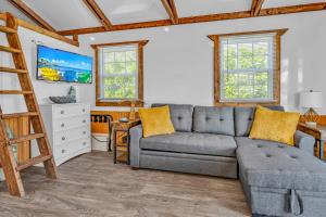 a living room with a gray couch and a ladder at Aqua Lodges at Coconut Cay Rv and Marina in Marathon