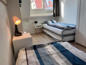 um quarto com duas camas e um candeeiro em Pollux bij Vuurtoren en strand em Noordwijk aan Zee