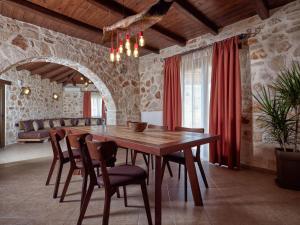 een eetkamer met een houten tafel en stoelen bij Villa Meralia in Anafonítria