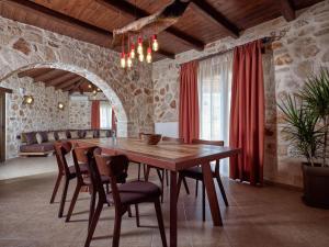 a dining room with a wooden table and chairs at Villa Meralia in Anafonítria