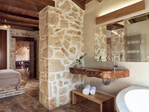 baño con lavabo y pared de piedra en Villa Meralia, en Anafonítria