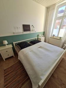 Un dormitorio con una gran cama blanca y una ventana en City-Wohnung Salzwedel en Salzwedel