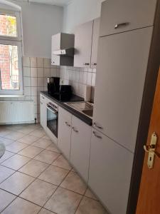 uma cozinha com electrodomésticos brancos e uma grande janela em City-Wohnung Salzwedel em Salzwedel