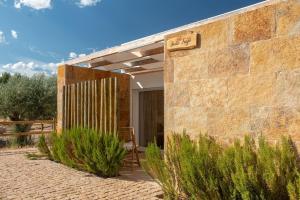 um edifício de tijolos com uma cadeira num pátio em Reflexos D'Alma Turismo Rural em Estremoz