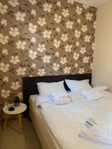 a bedroom with a bed with white flowers on the wall at Green life Bansko, 1 bedroom private apartment D4 in Bansko
