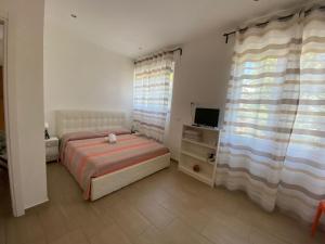 a bedroom with a bed and a television and curtains at b&b pellipario in Urbino