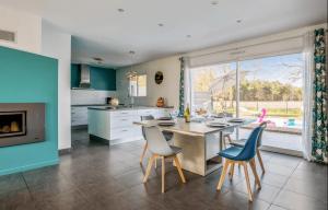 a kitchen with a table and chairs and a fireplace at Maison familiale au calme avec piscine securisee in Le Barp