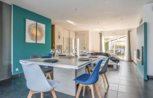 a kitchen with blue walls and a table and chairs at Maison familiale au calme avec piscine securisee in Le Barp