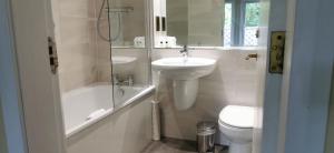 a white bathroom with a sink and a toilet at Old Manor Hotel in Lundin Links