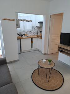 a living room with a table and a kitchen at Appartement Cosy, T2 Situé en Centre ville de Saint-Pierre in Saint-Pierre