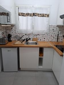 a kitchen with a sink and a counter with a window at Appartement Cosy, T2 Situé en Centre ville de Saint-Pierre in Saint-Pierre