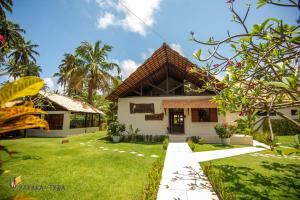 uma villa com um jardim e uma casa em Pousada Yapara-Tyba em Japaratinga