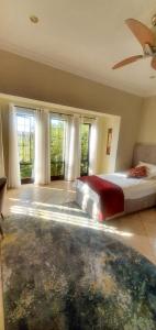 a bedroom with a bed in a room with windows at Sun view in Nelspruit