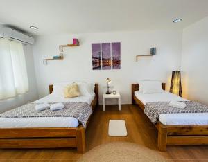 2 Betten in einem Zimmer mit weißen Wänden und Holzböden in der Unterkunft La View Mountain Resort in Damasanan