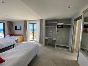 リル・ルッスにあるHôtel L'Isula Marinaのベッド2台が備わる海の景色を望むホテルルームです。