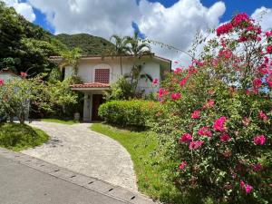 a house with pink flowers in front of a driveway at South Sea Ishigaki in Ishigaki Island
