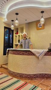 a man standing behind a counter in a room at Riad Dades Paradise in Boumalne Dades +37 photos
