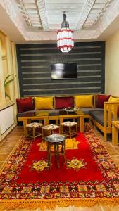 a living room with a couch and a red rug at Riad Dades Paradise in Boumalne Dades